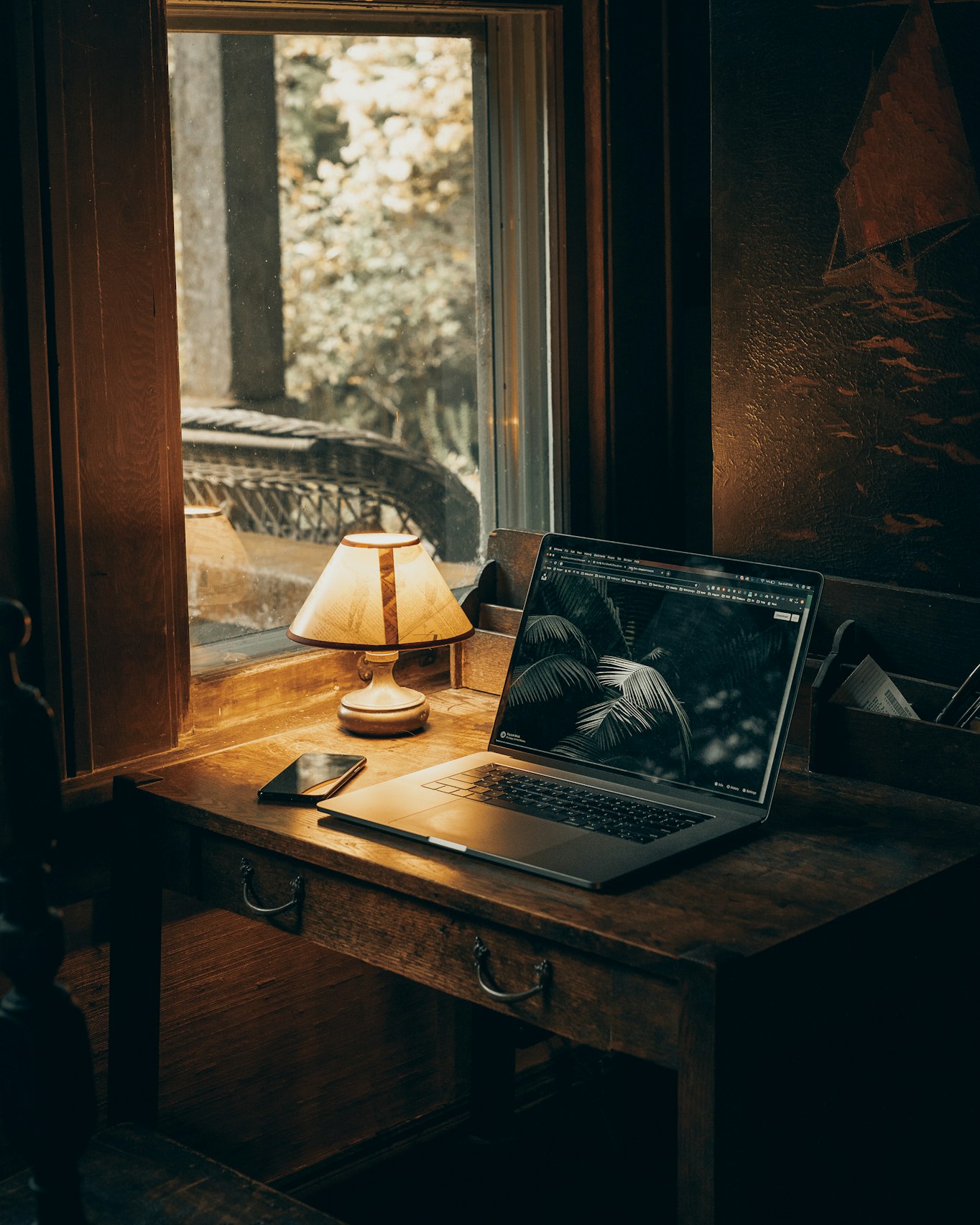 Schreibtisch mit Laptop und Lampe bei der Recherchearbeit